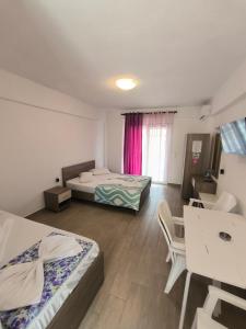 a room with two beds and a table and chairs at VILLA SEVI in Nea Vrasna