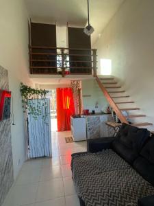 a living room with a couch and a staircase at Loft 11, caminho do mirante in Iguaba Grande