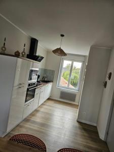 a kitchen with a large window and a table and chairs at O centre in Steenvoorde