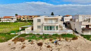 a house sitting on top of a beach next to buildings at iDream on the sea in Punta Braccetto