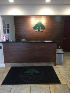 a reception desk with a tree on the wall at GreenTree Inn Flagstaff in Flagstaff