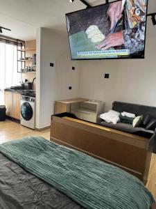 a room with a bed and a tv on the wall at Bela Curitiba Aparthotel in Curitiba