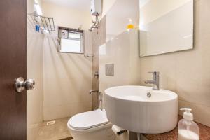 a bathroom with a white sink and a toilet at Golden Waves Holidays in Anjuna +30 photos