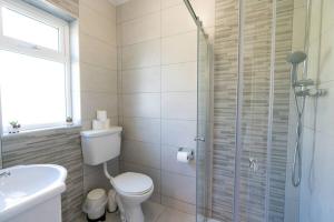 a bathroom with a toilet and a glass shower at Inch by the Sea - Sea Views in Inch +23 photos