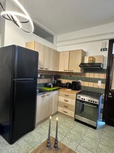 eine Küche mit einem schwarzen Kühlschrank und einem Tisch mit Kerzen. in der Unterkunft Le Rocher 2 in Ermoupoli