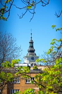 un bâtiment avec une tour d'horloge au sommet dans l'établissement CityCentre #nestaparamenty, à Bielsko-Biała