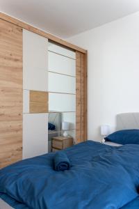 - une chambre avec un lit bleu et une tête de lit en bois dans l'établissement CityCentre #nestaparamenty, à Bielsko-Biała