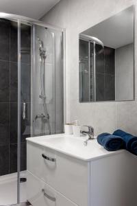 une salle de bain blanche avec lavabo et douche dans l'établissement CityCentre #nestaparamenty, à Bielsko-Biała