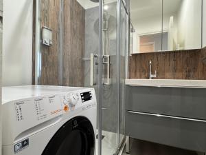 a washing machine in a bathroom with a shower at 70m2 climatisé - Parking privé - Terrasse - 2 chambres - Lycée Roosevelt - Reims Arena in Reims