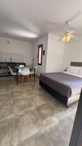 a bedroom with a bed and a table and a kitchen at Luz del Rincón in Merlo +42 photos