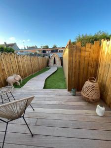 a wooden patio with a wooden fence and a wooden walkway at Les Secrets de la Baie - La Jimbaran - Suite d'exception Spa & Sauna in Étaples