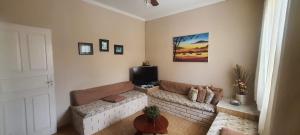 a living room with a couch and a tv at Casa aconchegante à 800 m da praia in Marataizes