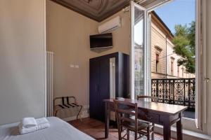 a bedroom with a bed and a table and a window at TRIBUNALE 4 LUXURY Rooms - BEDinBOLOGNACENTRO PALACE H in Bologna