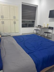 a bedroom with a blue bed with two chairs at Studio Résidence Prestige in Mahdia