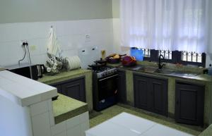 a kitchen with a stove and a sink at ViRRA Suites in Mbarara
