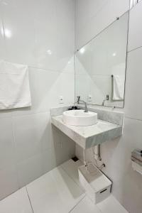 a white bathroom with a sink and a mirror at Ap 3 Ouro Pret com piscina aquecimento solar e churrasqueira in Ouro Preto
