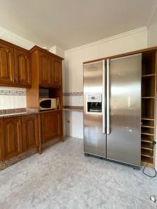eine Küche mit Edelstahlkühlschrank und Holzschränken in der Unterkunft Vivienda turística El Mirador de la Abuela in Ciudad-Rodrigo