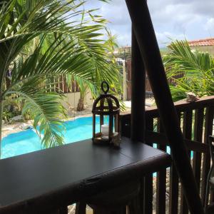 a table on a balcony with a view of a pool at Casa Chiquito in Savaneta +14 photos