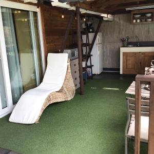 a room with green carpet and a chair on the floor at Casa Chiquito in Savaneta