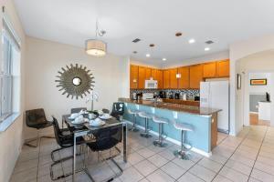 a kitchen with a table and some blue stools at 4BR Townhome with Lake View – BL481 in Kissimmee +36 photos