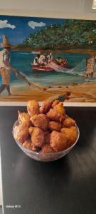 a plate of food on a table next to a painting at Studio de l'Anse Rouge Tartane in La Trinité