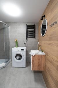 łazienka z pralką i umywalką w obiekcie Flow Apartments - przy Mariackiej w mieście Katowice