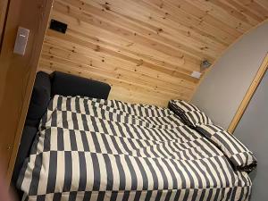 a bed in a small room with a wooden ceiling at Starview by MirrieMöra in Holm of Maywick