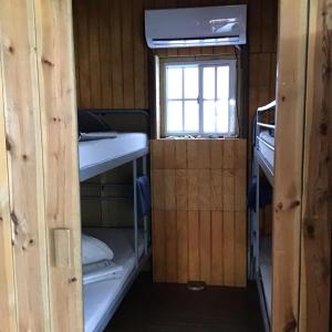 a small room with two bunk beds and a window at Casa Chiquito in Savaneta