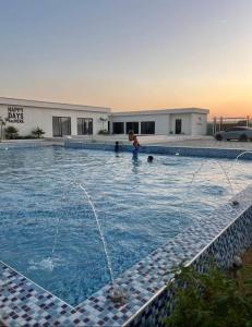 a child is playing in a swimming pool at La Granja de Zenón with pool near Sharjah Al Dhaid in á¸¨aÅŸat al BidÄ«yah