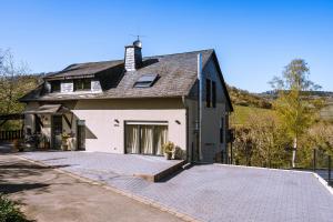 una gran casa blanca con entrada para coches en Premium Apartment Kahuna - Villa Rizas Hills, en Traben-Trarbach