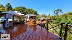 a wooden deck with a table and an umbrella at Pousada Chales da Mantiqueira - Campos do Jordão in Campos do Jordão +97 photos
