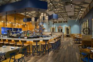 a bar in a restaurant with tables and chairs at Stay Salty-Newly Renovated-Barefoot Resort, 2 Pools, 2 miles to beach in North Myrtle Beach