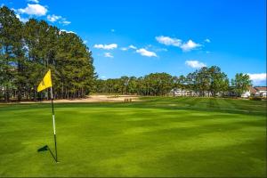a golf course with a yellow flag on the green at Stay Salty-Newly Renovated-Barefoot Resort, 2 Pools, 2 miles to beach in North Myrtle Beach