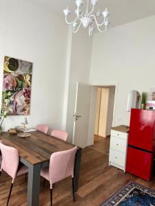 ein Esstisch mit rosa Stühlen und einem roten Kühlschrank in der Unterkunft Premium-Apartment im Duisburger Süden, nähe Düsseldorf Flughafen & Messe, Komplett ausgestattetes Apartment mit modernen Altbau-Flair in Duisburg + 24 Fotos