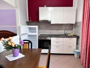 a kitchen with a wooden table with a vase of flowers at Appartamento "Rosa" in Casal Velino