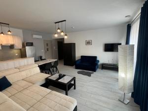 a living room with a couch and a table and a kitchen at MC Apartamenty Ściegiennego 3 in Augustów
