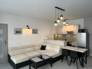 a living room with a couch and a kitchen at MC Apartamenty Ściegiennego 3 in Augustów