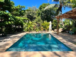 a swimming pool in front of a villa at Apartamentos El Labrador in Tamarindo