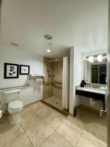 a bathroom with a toilet and a sink and a shower at Country Inn & Suites by Radisson, Port Charlotte, FL in Port Charlotte +37 photos