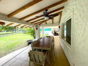 a patio with a table and chairs and a ceiling fan at Casa En Campo de Golf, Lomas de Cocoyoc in Texcalpan