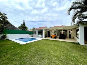 a house with a swimming pool in the yard at Casa En Campo de Golf, Lomas de Cocoyoc in Texcalpan