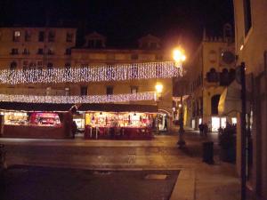 una strada di notte con luci di Natale su un edificio di Cristina House a Bassano del Grappa