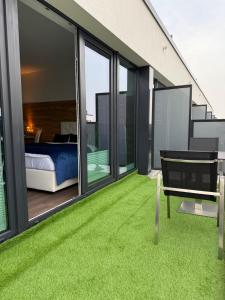 a balcony with a bedroom and green grass at Maritimes Luxusapartment in Rostock