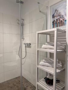 a bathroom with a shower and a rack with towels at Maritimes Luxusapartment in Rostock