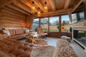 a living room with a couch and a fireplace at Forest Chalet with Jacuzzi and sauna, 4 km from Starý Smokovec in Nová Lesná