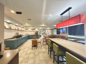 a restaurant with a bar and tables and chairs at Country Inn & Suites by Radisson, Port Charlotte, FL in Port Charlotte