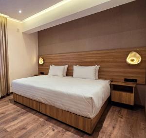 a bedroom with a large bed with a wooden headboard at Hotel Bankir Khiva in Khiva