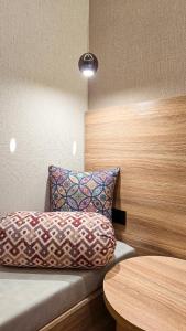 a room with a couch with a pillow and a table at Hotel Bankir Khiva in Khiva