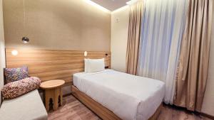 a hotel room with two beds and a chair at Hotel Bankir Khiva in Khiva