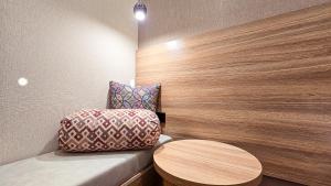 a room with a bench with a table and a chair at Hotel Bankir Khiva in Khiva